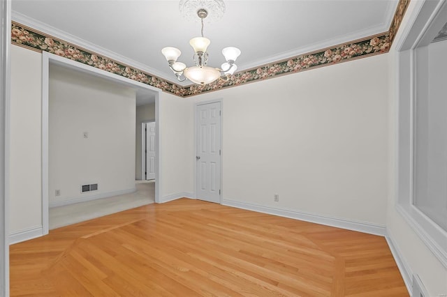 spare room featuring an inviting chandelier, ornamental molding, baseboards, light wood finished floors, and visible vents