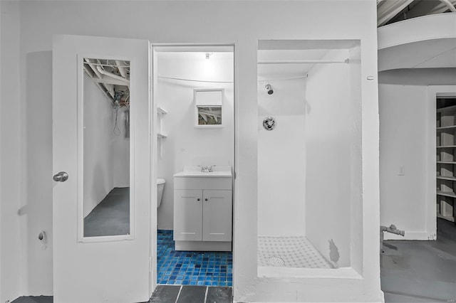 bathroom with tile patterned floors, vanity, toilet, and a shower