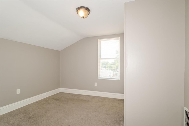 additional living space with vaulted ceiling and light colored carpet