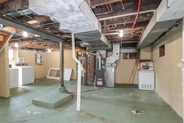 basement featuring gas water heater, washer and dryer, electric panel, heating unit, and brick wall