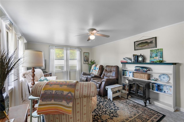 carpeted living room featuring a wood stove, ceiling fan, and ornamental molding