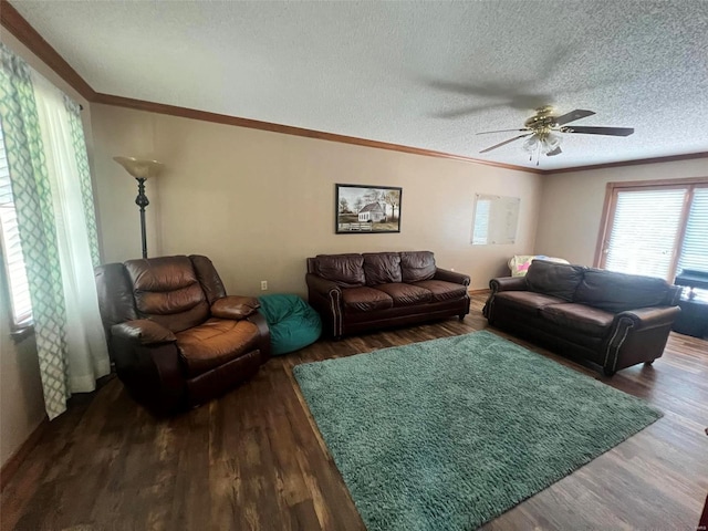 living room featuring ornamental molding, dark wood-type flooring, a textured ceiling, and ceiling fan