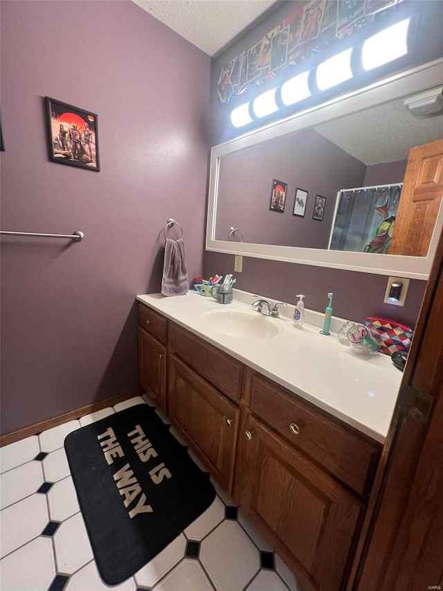 bathroom featuring tile patterned flooring, vanity, and a textured ceiling