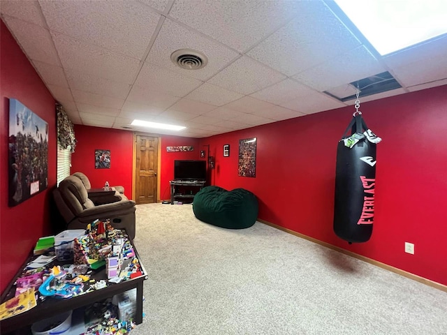 recreation room featuring carpet floors and a drop ceiling