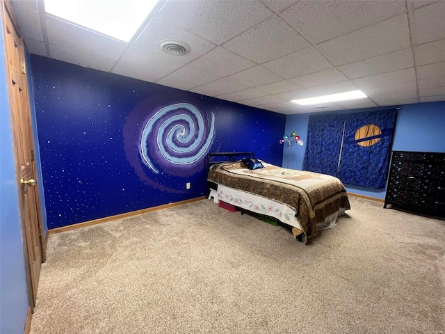 bedroom with a drop ceiling and carpet floors