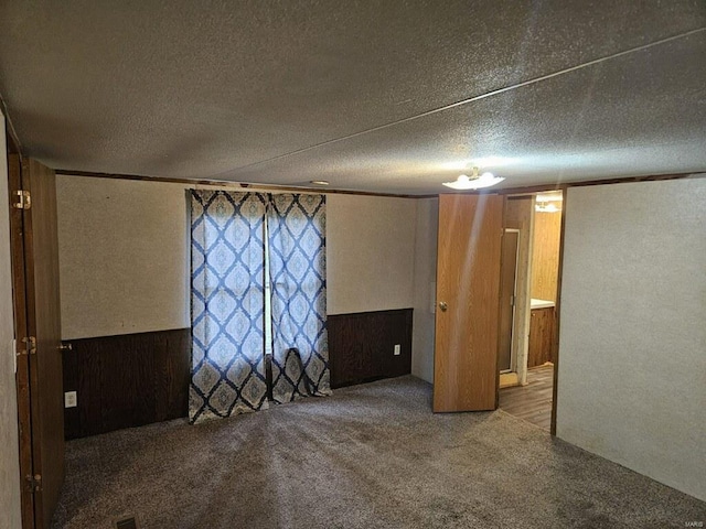 interior space featuring crown molding, a textured ceiling, and carpet floors