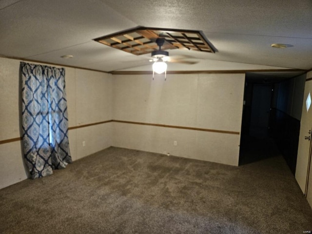 carpeted spare room with a textured ceiling, ceiling fan, and lofted ceiling