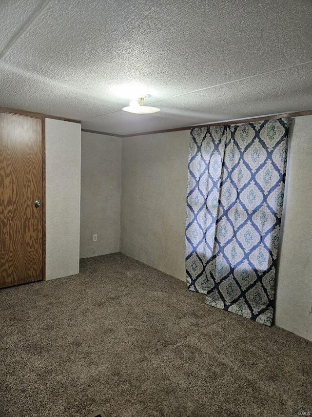 unfurnished room featuring a textured ceiling and carpet floors