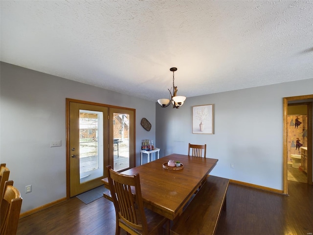 dining space featuring a textured ceiling, a chandelier, and dark hardwood / wood-style floors