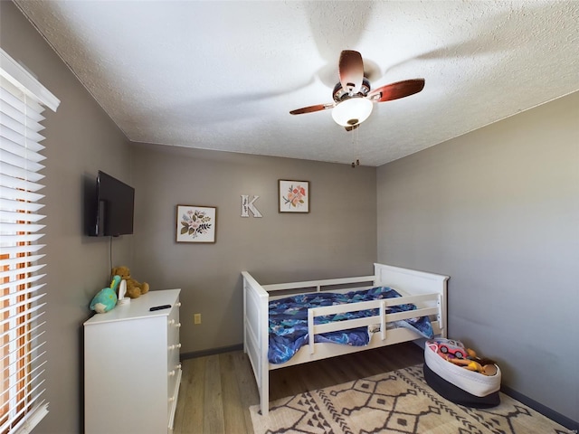 bedroom featuring a textured ceiling, ceiling fan, and light hardwood / wood-style floors