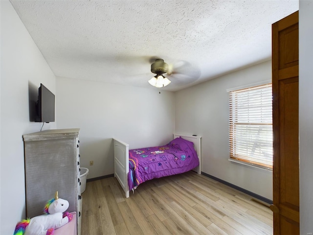 bedroom featuring a textured ceiling, light hardwood / wood-style flooring, and ceiling fan