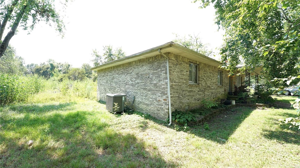 view of home's exterior with central AC unit and a yard