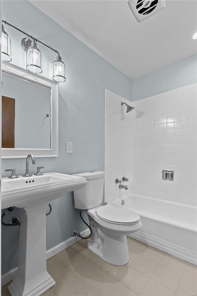 bathroom with tiled shower / bath combo and toilet