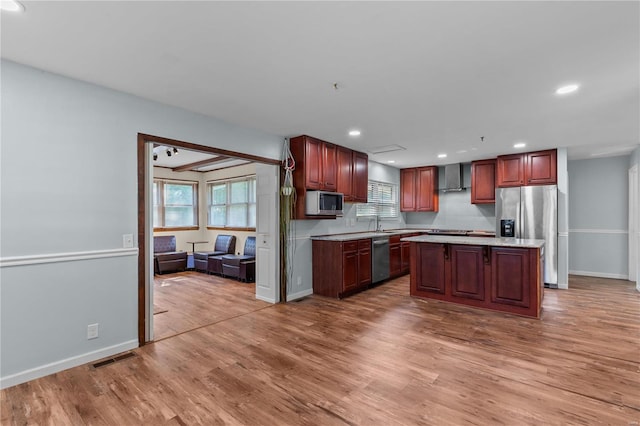 kitchen featuring hardwood / wood-style floors, stainless steel appliances, and a kitchen island