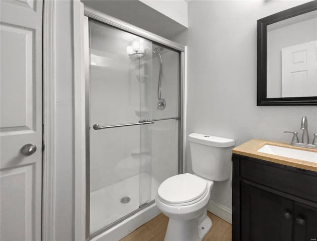 bathroom with vanity, toilet, an enclosed shower, and wood-type flooring