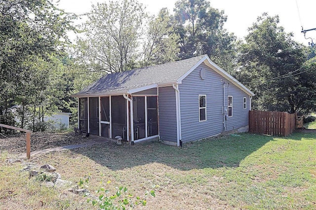 back of house with a sunroom and a lawn