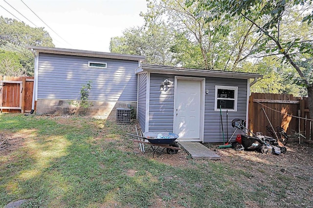 rear view of property with a yard, a shed, and central AC unit