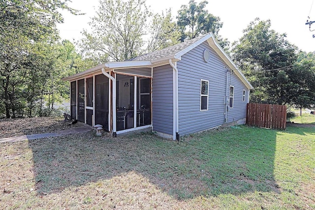 view of outdoor structure featuring a sunroom and fence