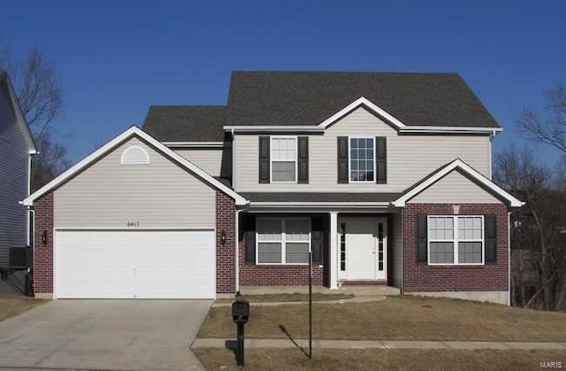 front of property featuring covered porch, central air condition unit, and a garage