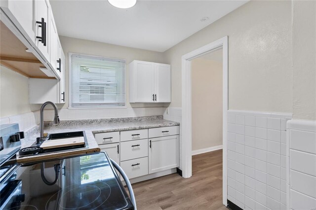 kitchen featuring light wood-type flooring and white cabinetry