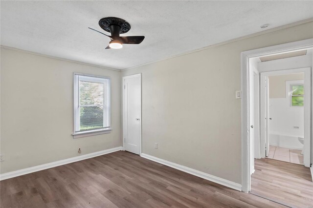 unfurnished room with crown molding, a textured ceiling, ceiling fan, and dark hardwood / wood-style floors