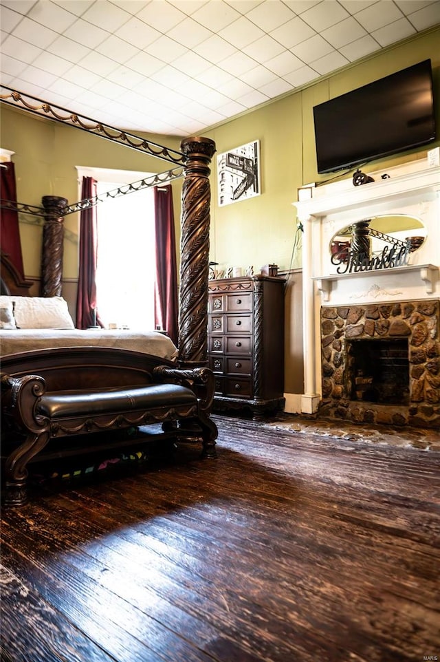 bedroom featuring a fireplace and hardwood / wood-style flooring