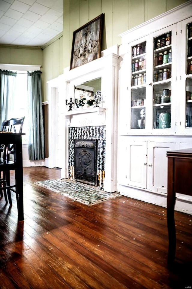 living room with wood-type flooring and a tile fireplace