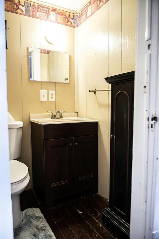 bathroom featuring vanity, toilet, and hardwood / wood-style floors