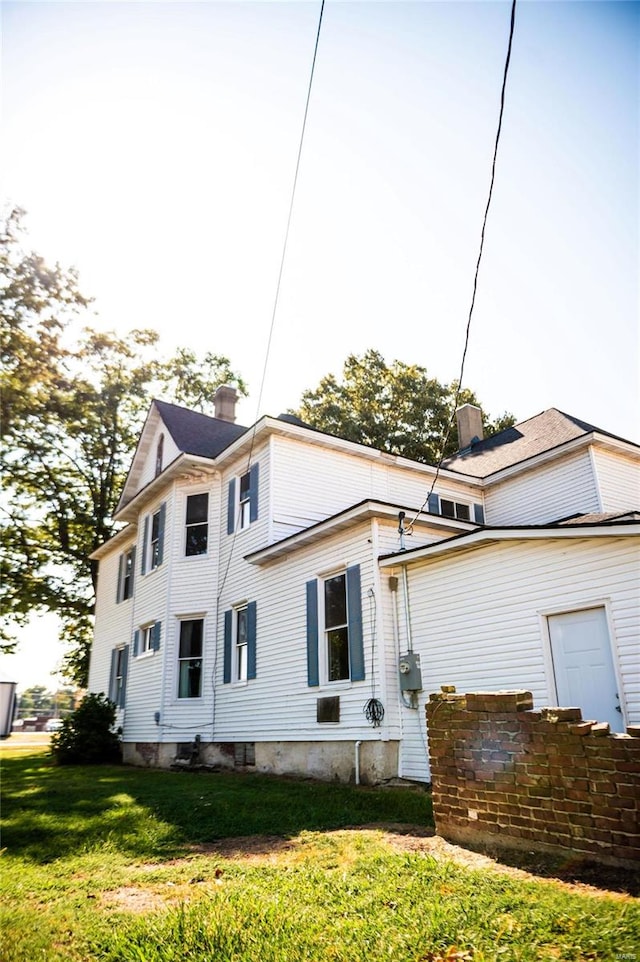 rear view of house featuring a yard