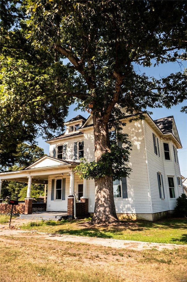 view of front of house with a porch and a front lawn