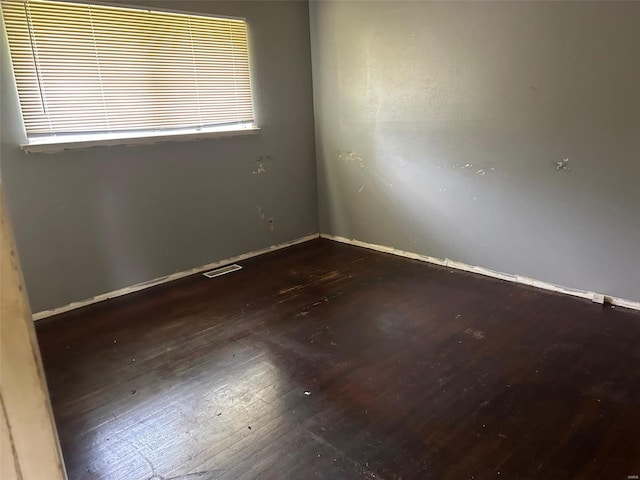 empty room featuring wood-type flooring and a healthy amount of sunlight