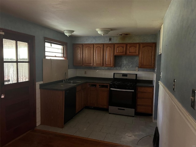 kitchen with light tile patterned floors, dishwasher, stainless steel stove, and sink