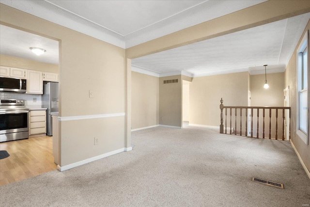 empty room with light colored carpet, visible vents, and baseboards