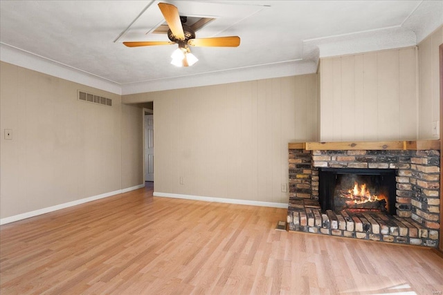 unfurnished living room with visible vents, wood finished floors, a fireplace, baseboards, and ceiling fan