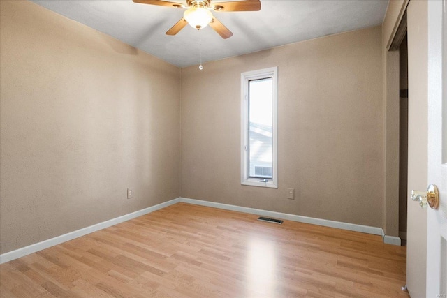 spare room featuring light wood-style flooring, baseboards, and ceiling fan