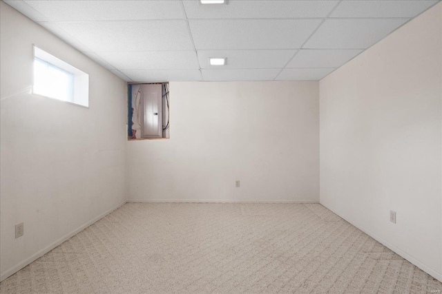 basement with carpet flooring, electric panel, and a drop ceiling