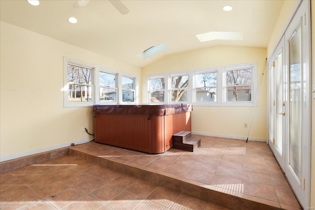 interior space with vaulted ceiling with skylight and a healthy amount of sunlight