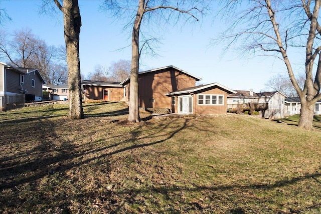 back of house with a lawn and a residential view