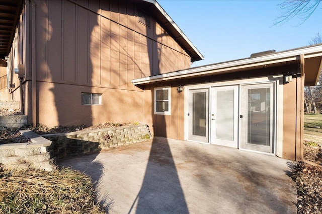 back of property featuring board and batten siding and a patio