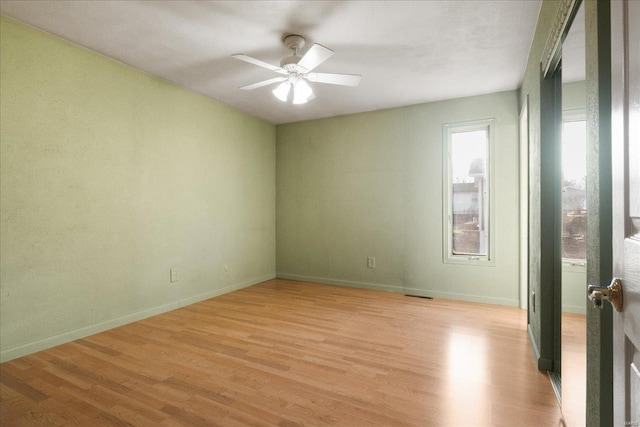 unfurnished room featuring ceiling fan, visible vents, baseboards, and light wood-style flooring