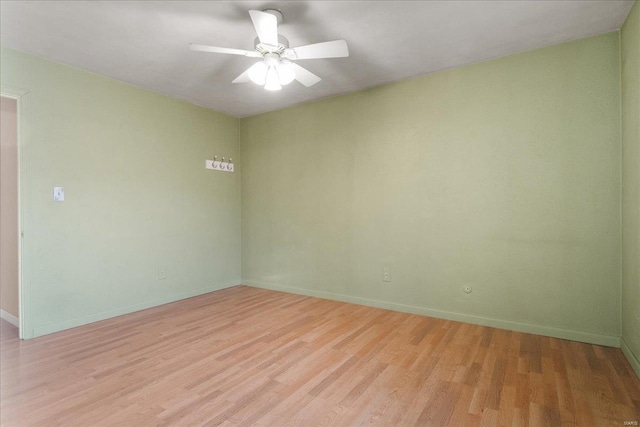 spare room featuring light wood-style flooring, baseboards, and ceiling fan