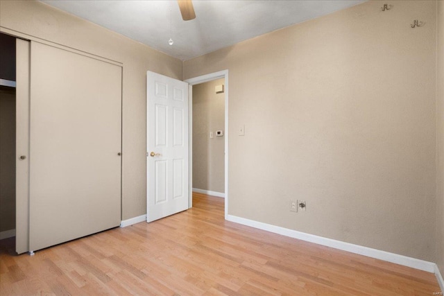 unfurnished bedroom with a closet, baseboards, a ceiling fan, and light wood finished floors