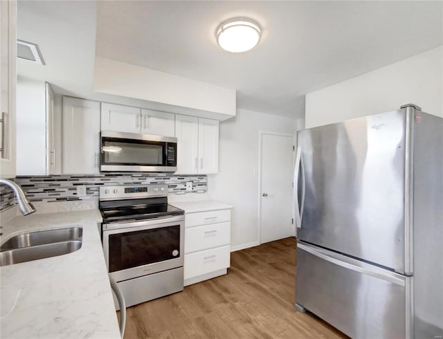 kitchen featuring light hardwood / wood-style flooring, stainless steel appliances, sink, and backsplash