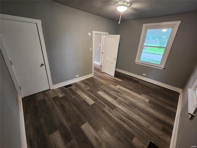 unfurnished bedroom featuring ceiling fan and dark hardwood / wood-style floors