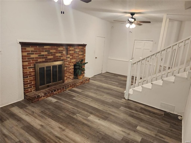 unfurnished living room featuring ceiling fan, a fireplace, and dark hardwood / wood-style flooring