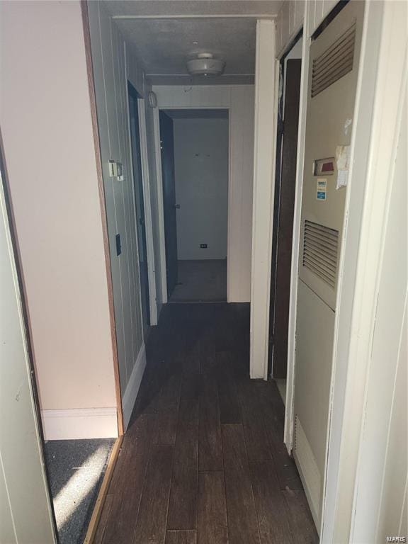 corridor featuring a barn door and dark hardwood / wood-style floors