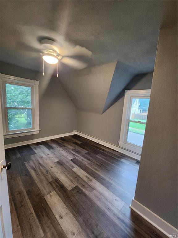 additional living space with lofted ceiling, dark hardwood / wood-style flooring, and ceiling fan