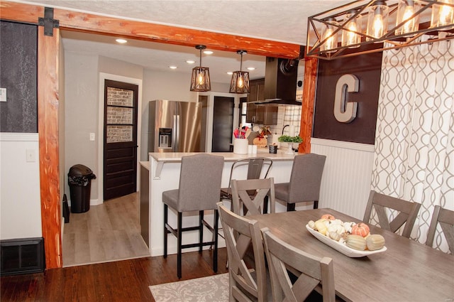 dining space featuring a textured ceiling, wood-type flooring, and a barn door