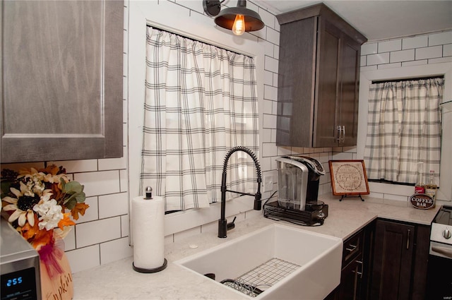 kitchen featuring decorative backsplash, sink, dark brown cabinets, and white electric range