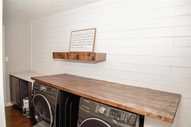 clothes washing area with washer / clothes dryer, a textured ceiling, and dark hardwood / wood-style floors